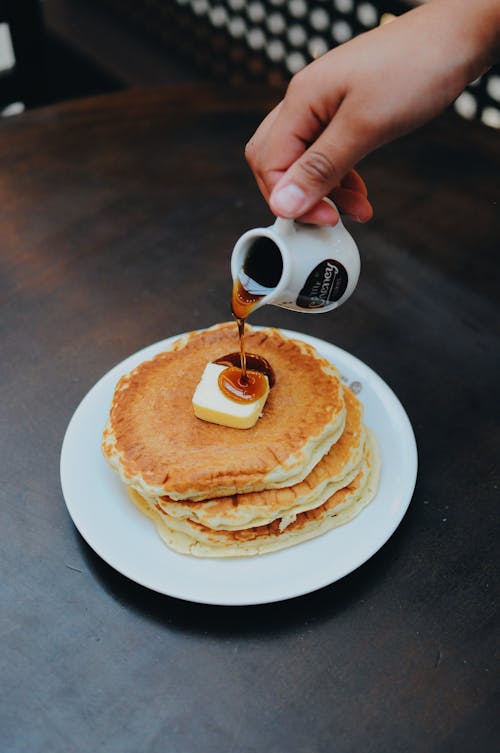 Free Person Pouring Syrup on Pancake Stock Photo
