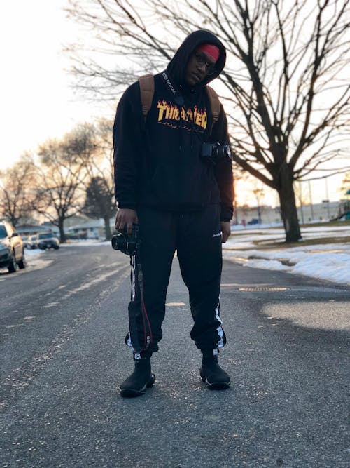 Photo of Man Wearing Hoodie Standing on Road