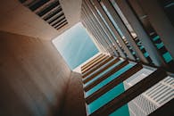 低角度视角下的现代建筑结构，以开阔的天空为背景，凸显了当代设计与几何美感