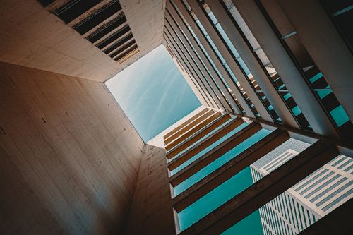 Free Low angle view of a modern building structure with open sky, emphasizing contemporary design and geometry. Stock Photo