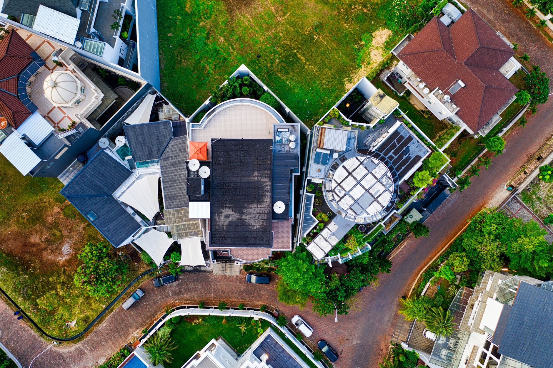 Aerial view of residential architecture in Jakarta, featuring rooftops and green spaces.