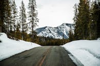 山路两侧风景优美，白雪皑皑的针叶林与远处的山峰相映成趣