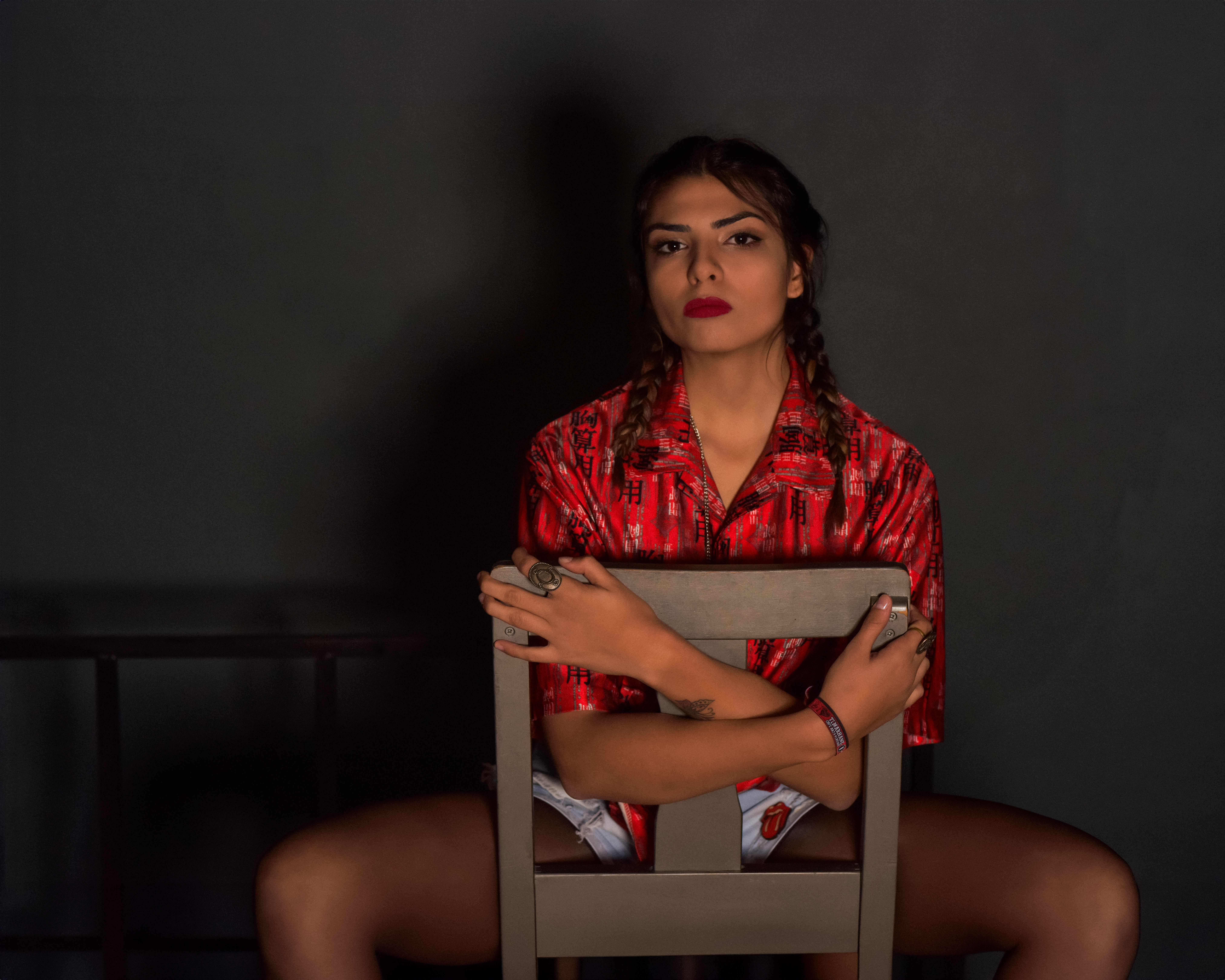 A woman sitting on a chair in a dark room · Free Stock Photo