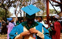 在充满活力和庆祝气氛的户外仪式上，毕业生们调整着礼服