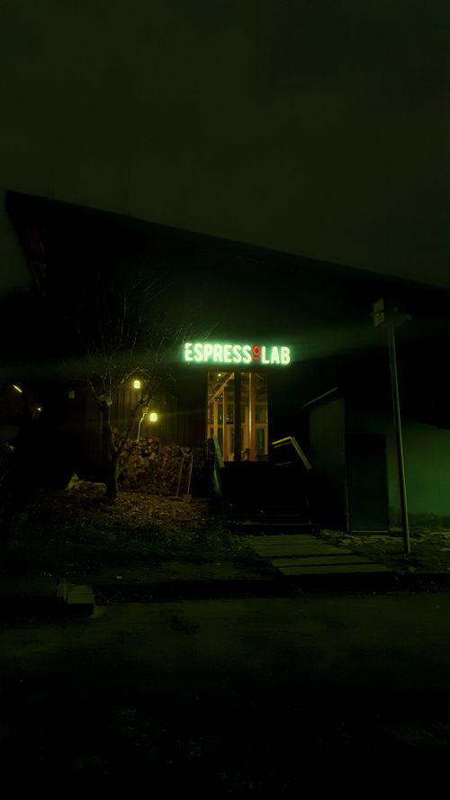 Free Moody urban entrance of a café with green neon sign at night. Stock Photo