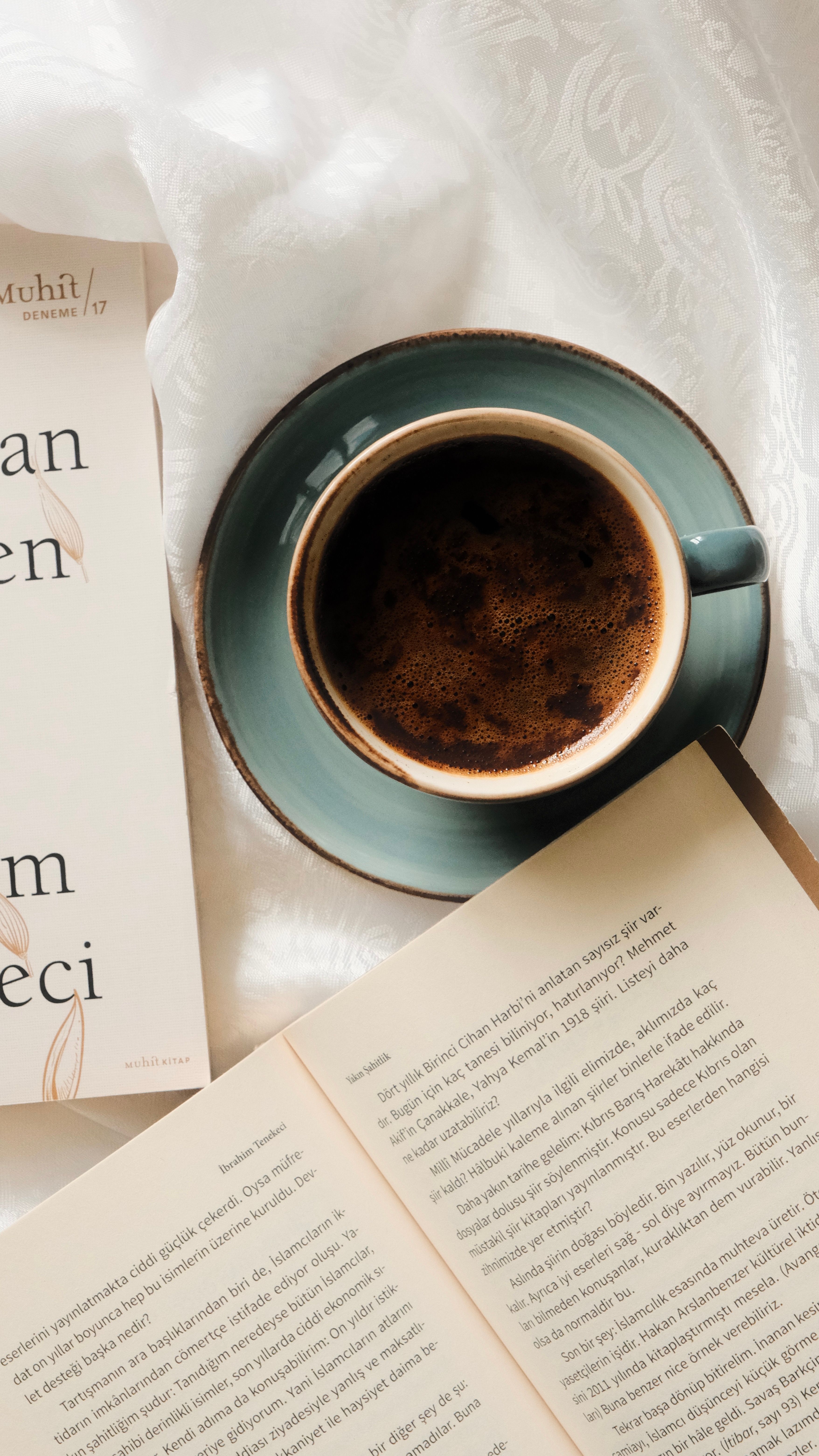 Top view of a cup of coffee and an open book on a soft background, perfect for relaxation themes.