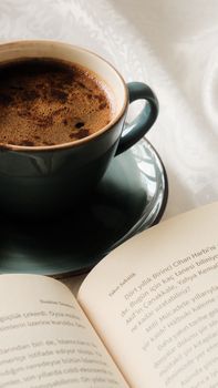 A cozy scene of a steaming coffee cup beside an open book, ideal for relaxation themes.