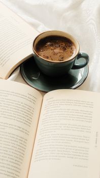 A comforting scene of a coffee cup beside an open book, perfect for a cozy morning.