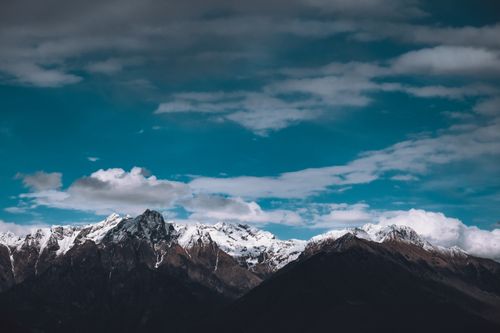 Free A stunning view of snowcapped mountains under a bright blue sky with clouds. Stock Photo