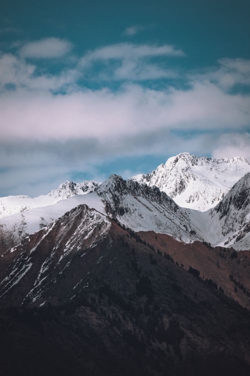 Free Majestic snowcapped mountains against a vibrant blue sky, showcasing natural beauty. Stock Photo