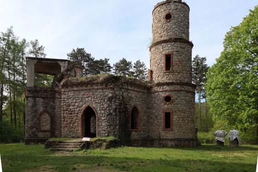 Explore the mystery and history of a medieval stone ruin set amid lush, green forest foliage.