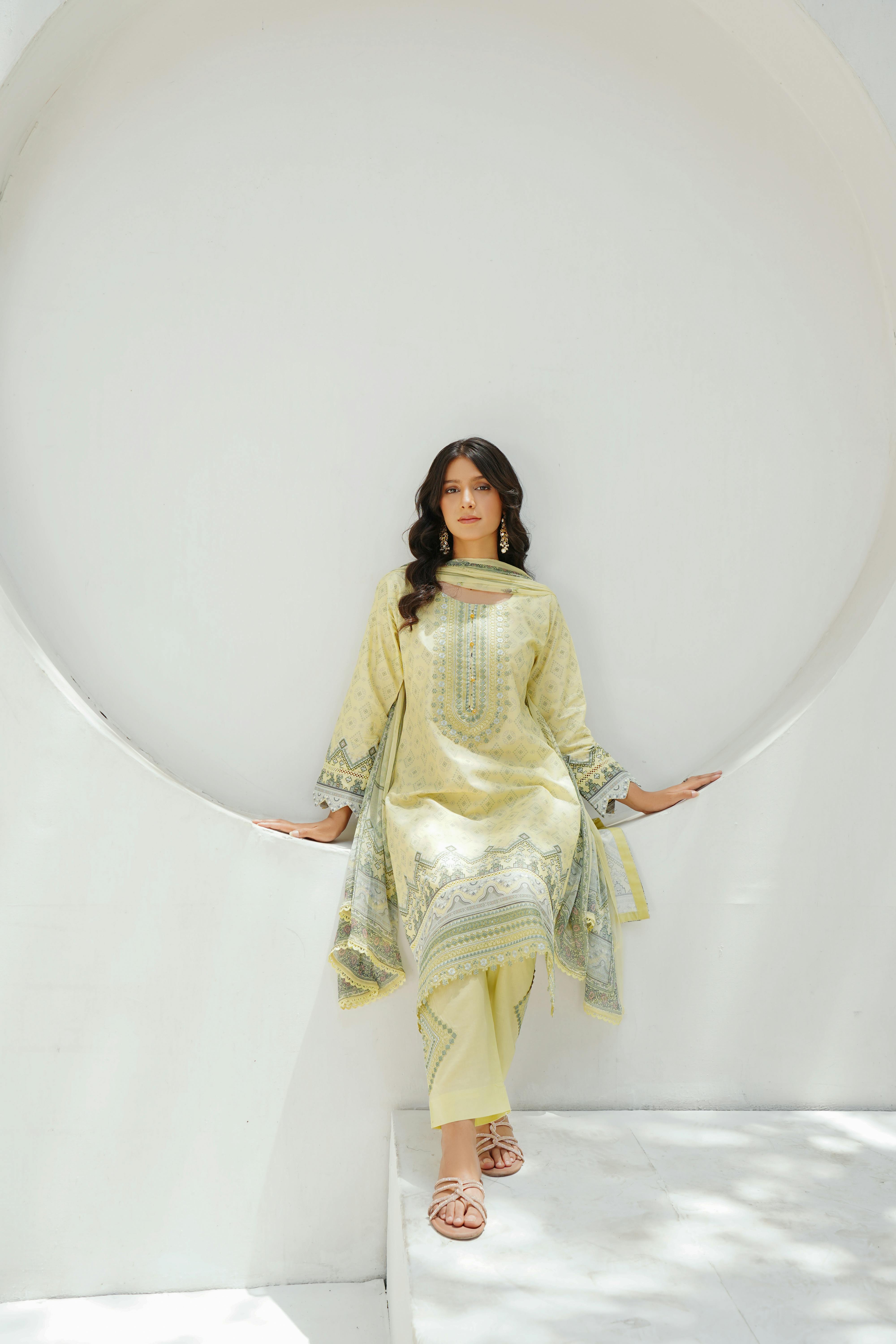 Woman posing in traditional Lahore fashion, wearing yellow salwar kameez.