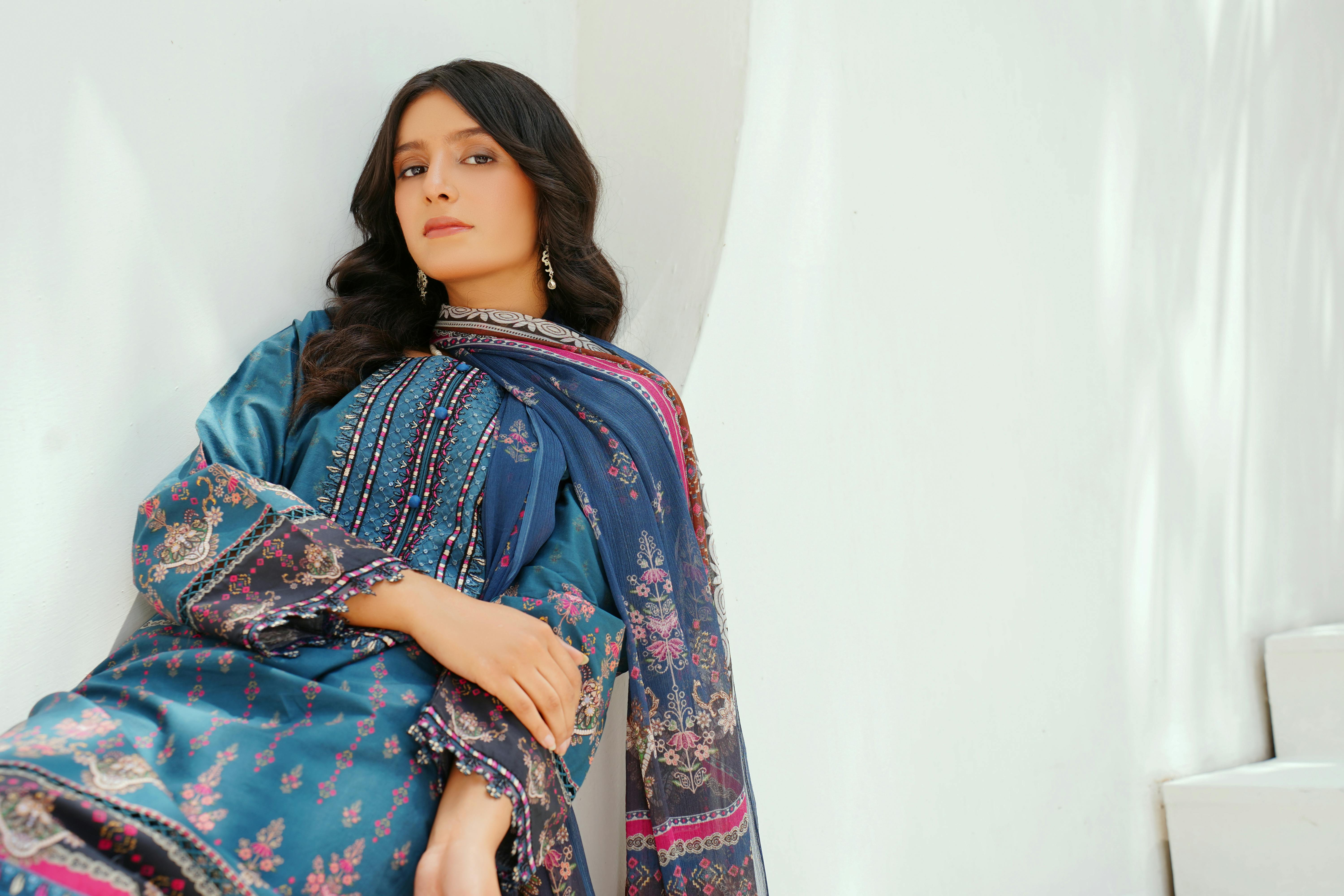 model in traditional blue dress with embroidery and scarf