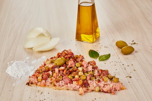 A pizza with olives, onions and garlic on a wooden table