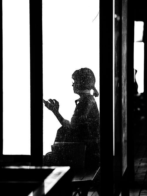 Free Artistic silhouette of a woman sitting by a window, captured in black and white. Stock Photo