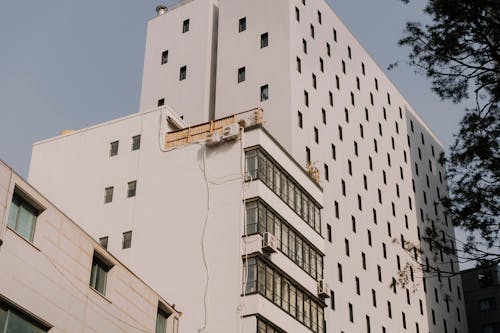 A tall building with a white roof and windows