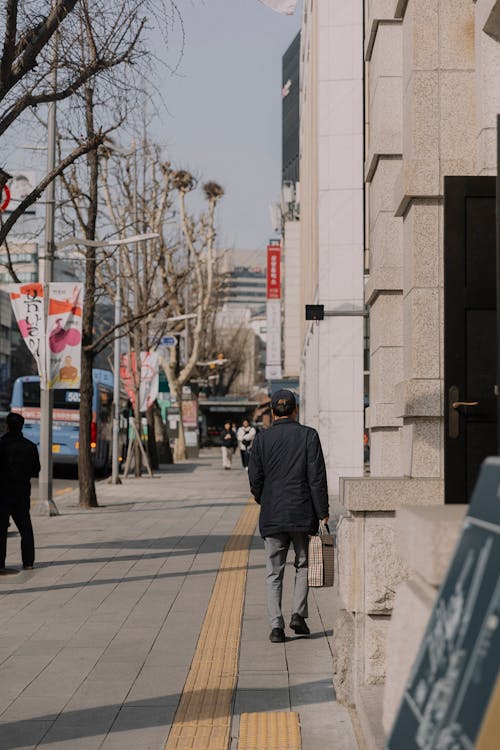 Free Man in Jacket Walking on Sidewalk Stock Photo