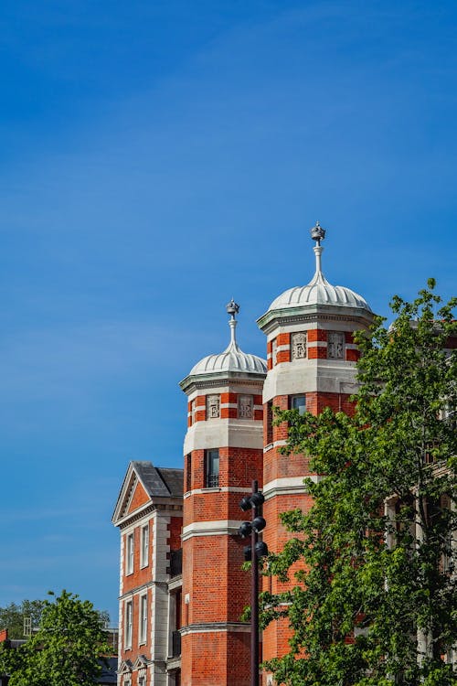 A large red brick building with two towers on top