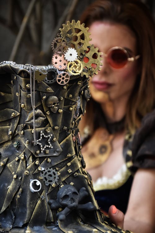 A woman is holding a steampunk dress with gears