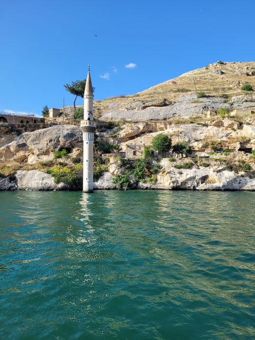 Free A picturesque view of a minaret rising from the river in Halfeti, Turkey, under a clear blue sky. Stock Photo
