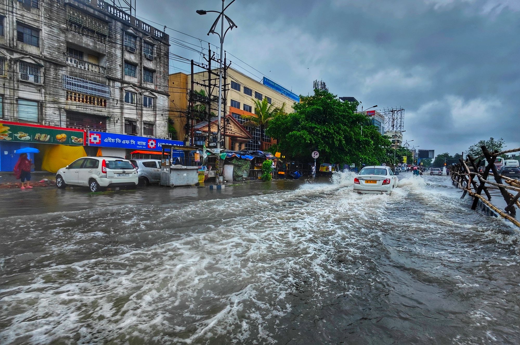 A busy urban street in Kolkata flooded after heavy monsoon rains, showcasing urban infrastructure challenges.