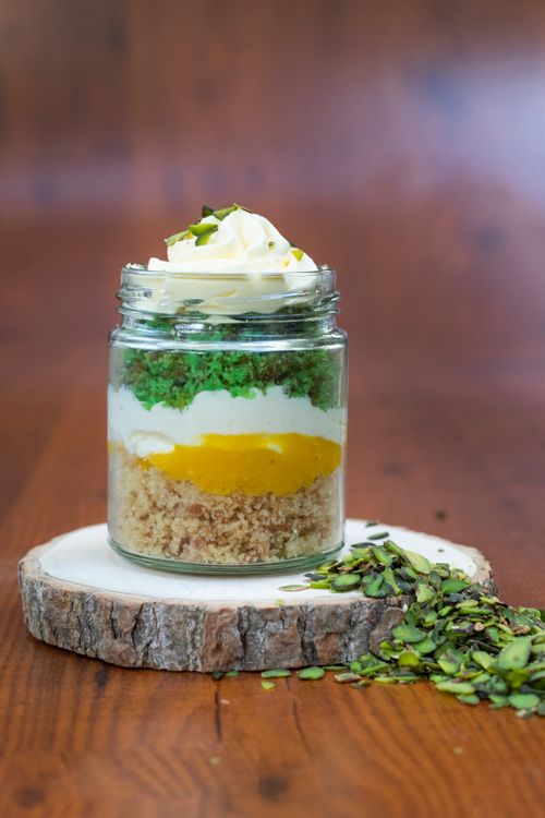 Free Layered dessert jar with cream, herbs, and fruit on wooden background. Stock Photo