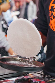 Capturing the action of a street vendor preparing traditional tapioca in São Paulo, Brazil.
