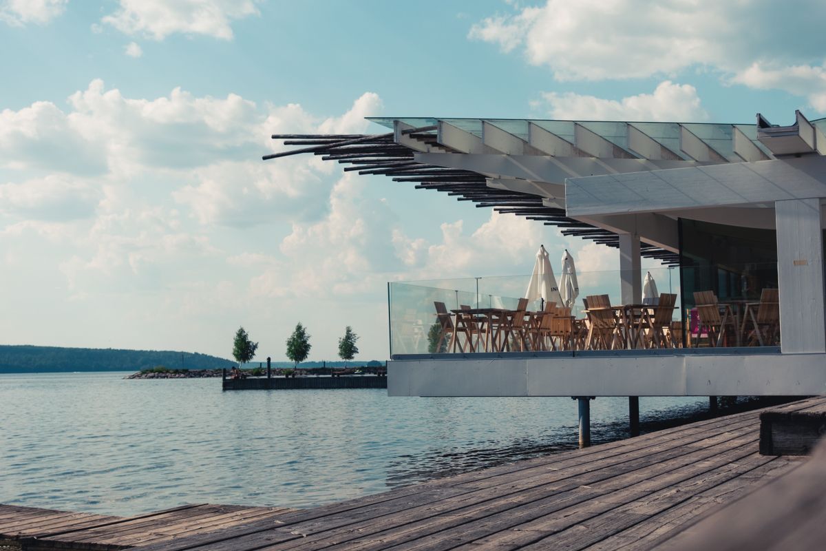 Outdoor waterfront patio restaurant with dining tables overlooking water