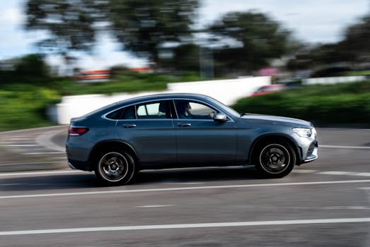 A sleek car speeds down a city street, capturing the essence of urban transportation.