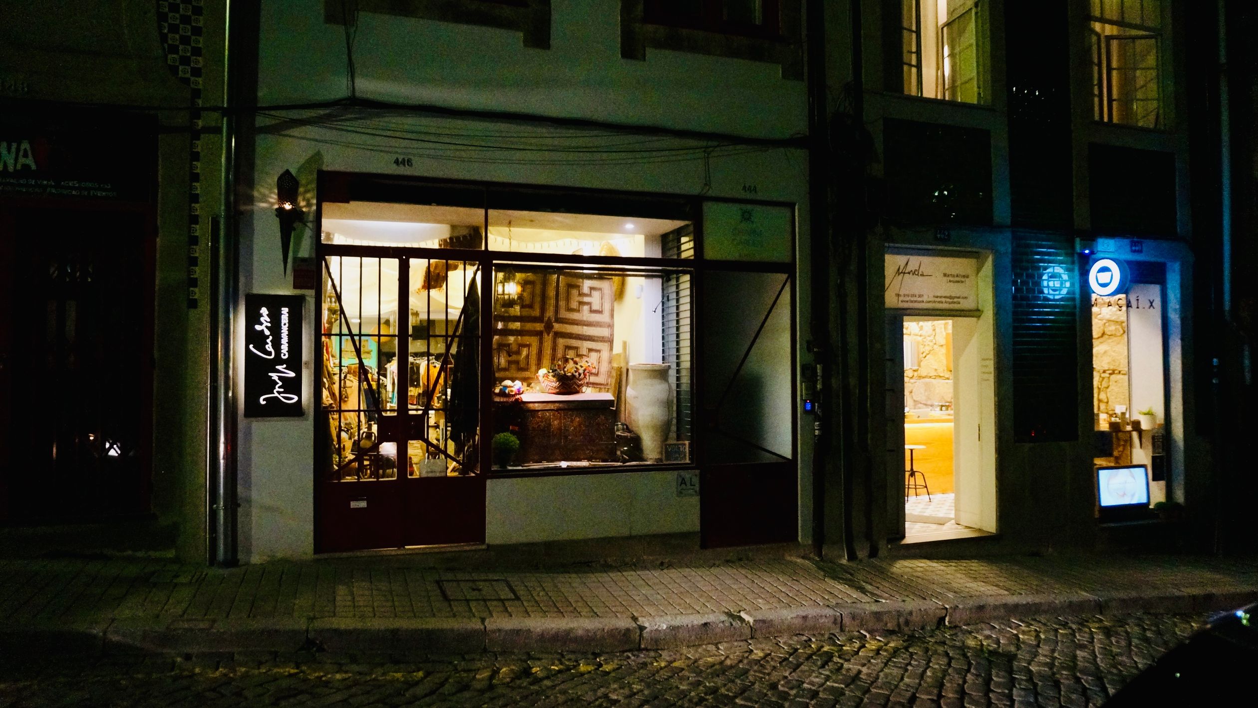 Cozy shopfront in Porto, Portugal, illuminated at night, showcasing vintage decorations.