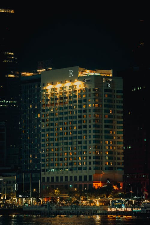 A hotel lit up at night by the water