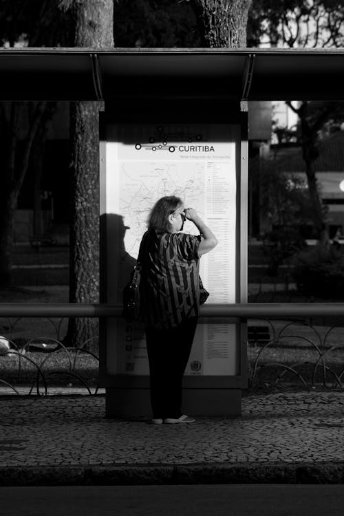 A woman standing at a bus stop