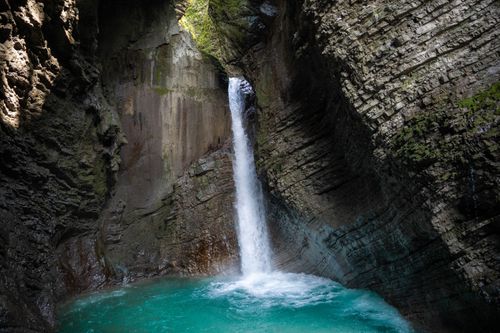 Free Stunning waterfall cascading in a secluded rocky gorge with turquoise water. Stock Photo