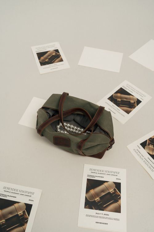 Green leather bag styled with fashion brochures