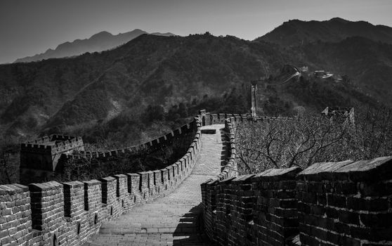 Stunning black and white capture of the Great Wall of China winding through mountainous landscape.
