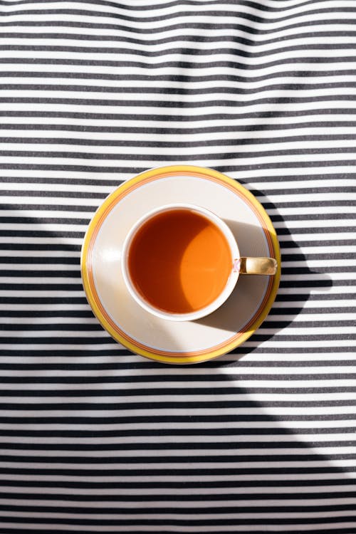 A cup of tea on a striped bed