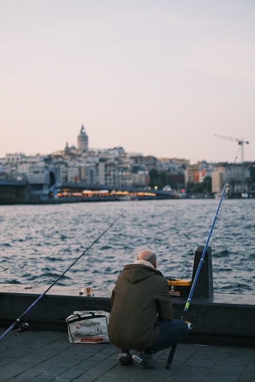 A man sitting on the ground with his fishing rod
