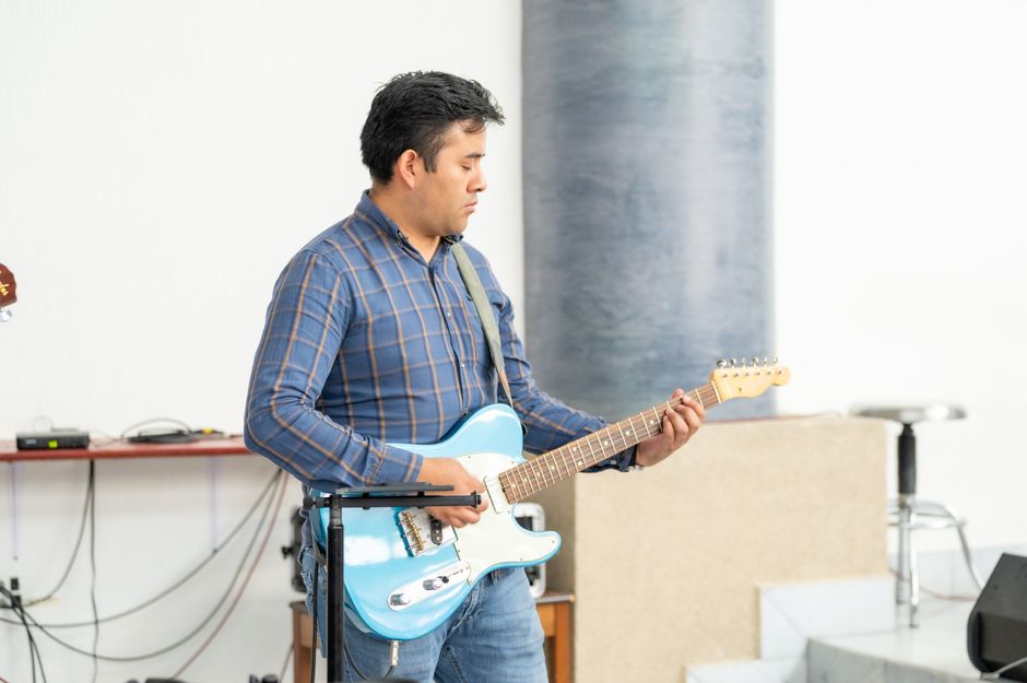 Casual indoor performance by a young man playing an electric guitar in Ciudad de México.