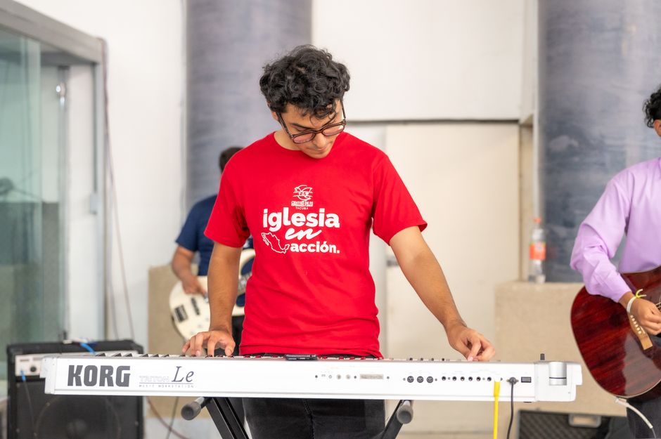 A young musician playing a keyboard during a church event in Mexico City.