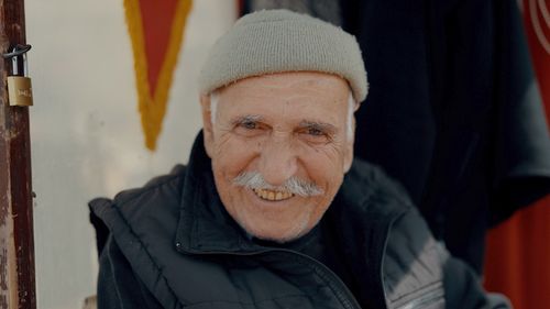 Free A cheerful elderly man with a mustache wearing winter attire and smiling warmly in Istanbul. Stock Photo