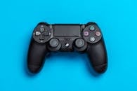 黑色游戏控制器与充满活力的蓝色背景相搭配，非常适合游戏主题内容