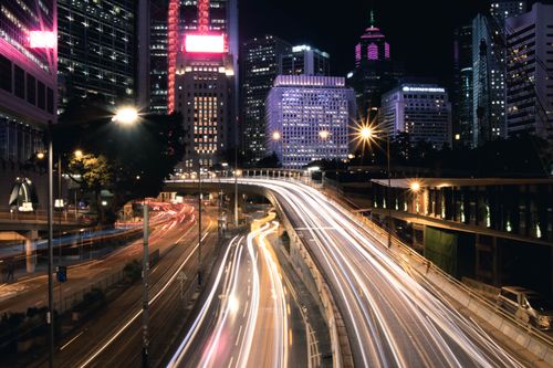 Free Dynamic night cityscape of Hong Kong with vibrant light trails and skyscrapers. Stock Photo