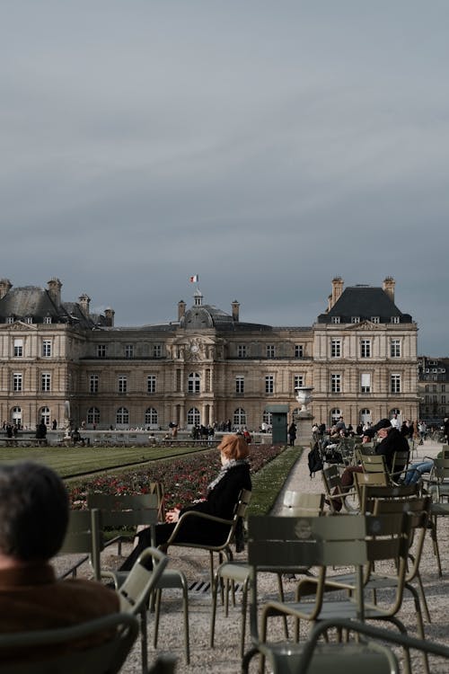 People sitting in chairs in front of a palace