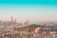 在晴朗的白天天空下，旧金山的天际线鸟瞰图令人惊叹，展示了现代摩天大楼和标志性的海湾大桥