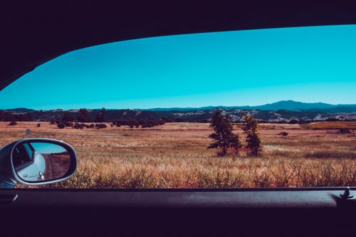 Free View of a vast field and mountains from inside a car, showcasing a beautiful summer day. Stock Photo