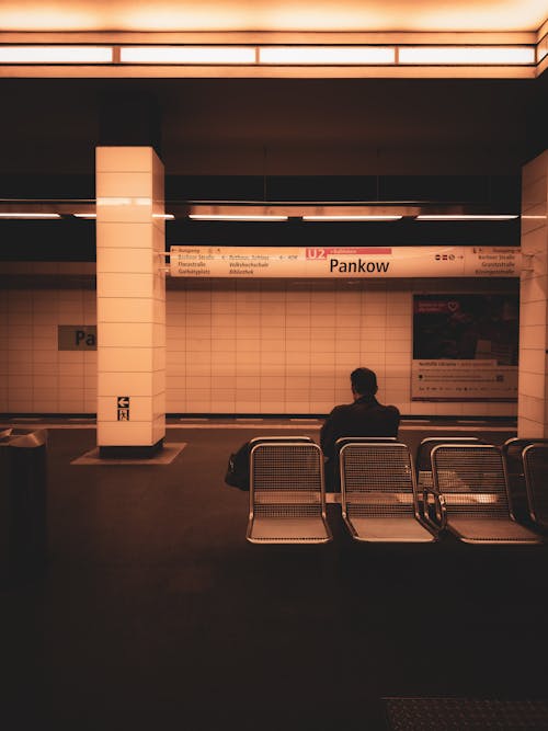 A man sitting on a bench in a subway station