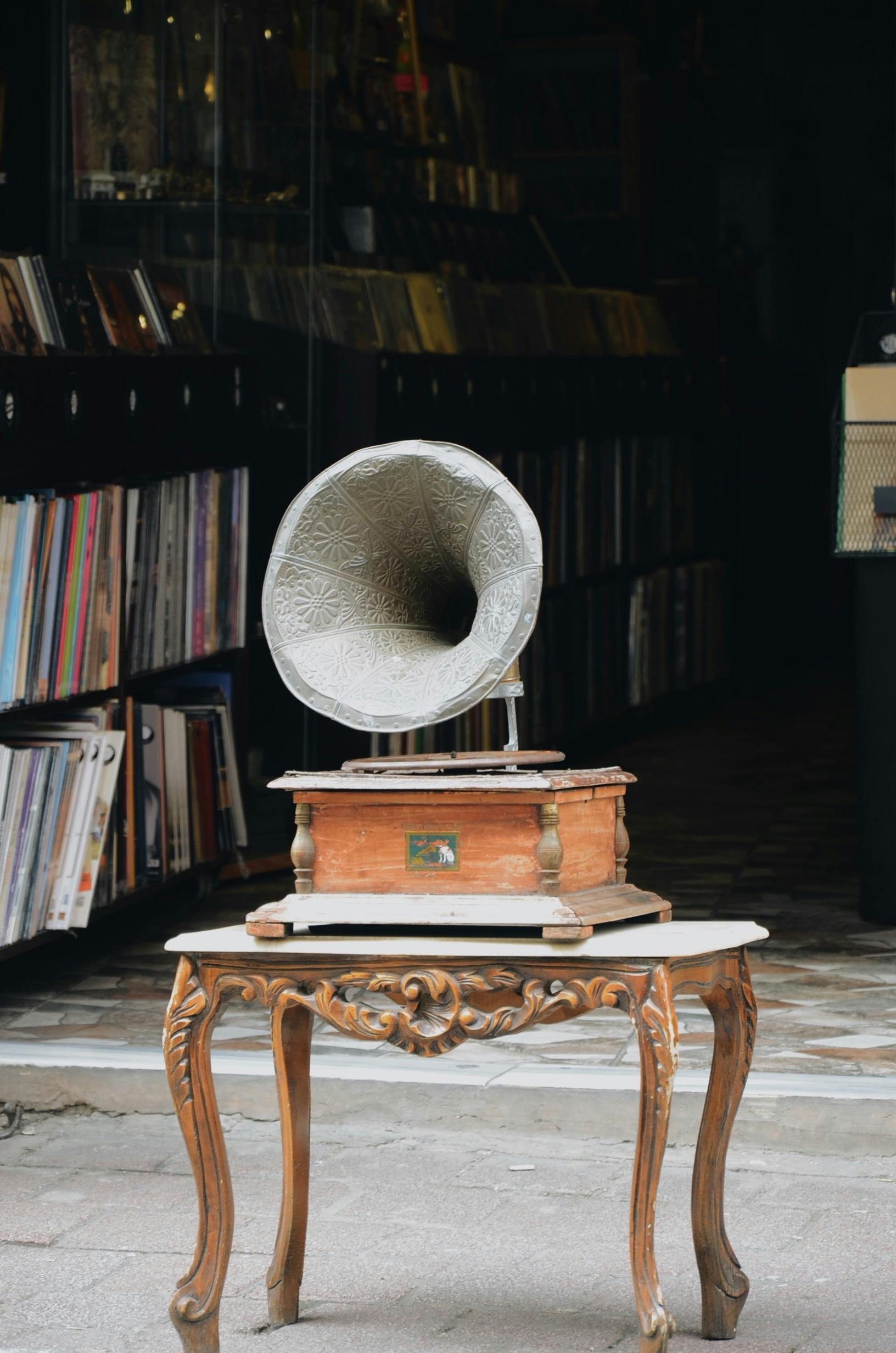Antique gramophone displayed on a beautifully carved wooden table, evoking nostalgia.