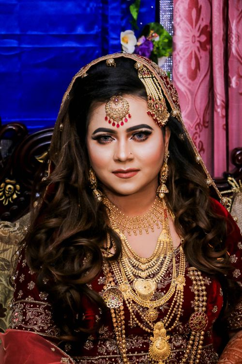 Free Capture of an elegant bride adorned in traditional gold jewelry and exquisite attire. Stock Photo