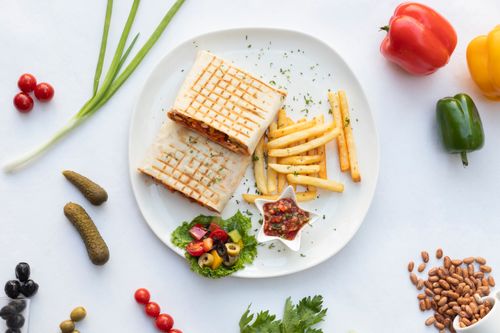 Free A vibrant food platter featuring wraps, french fries, and fresh vegetables, perfect for lunch. Stock Photo
