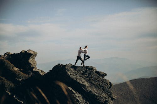 Two people are standing on top of a mountain